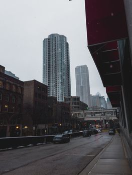 City view showing skyscrapers and street traffic under an overcast sky.