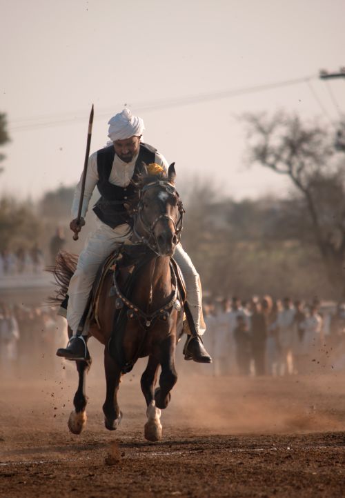 Free A dynamic capture of a man in traditional attire riding a horse at a cultural event. Stock Photo