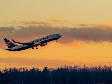Ryanair airplane taking off against a beautiful sunset in Wrocław, Poland.