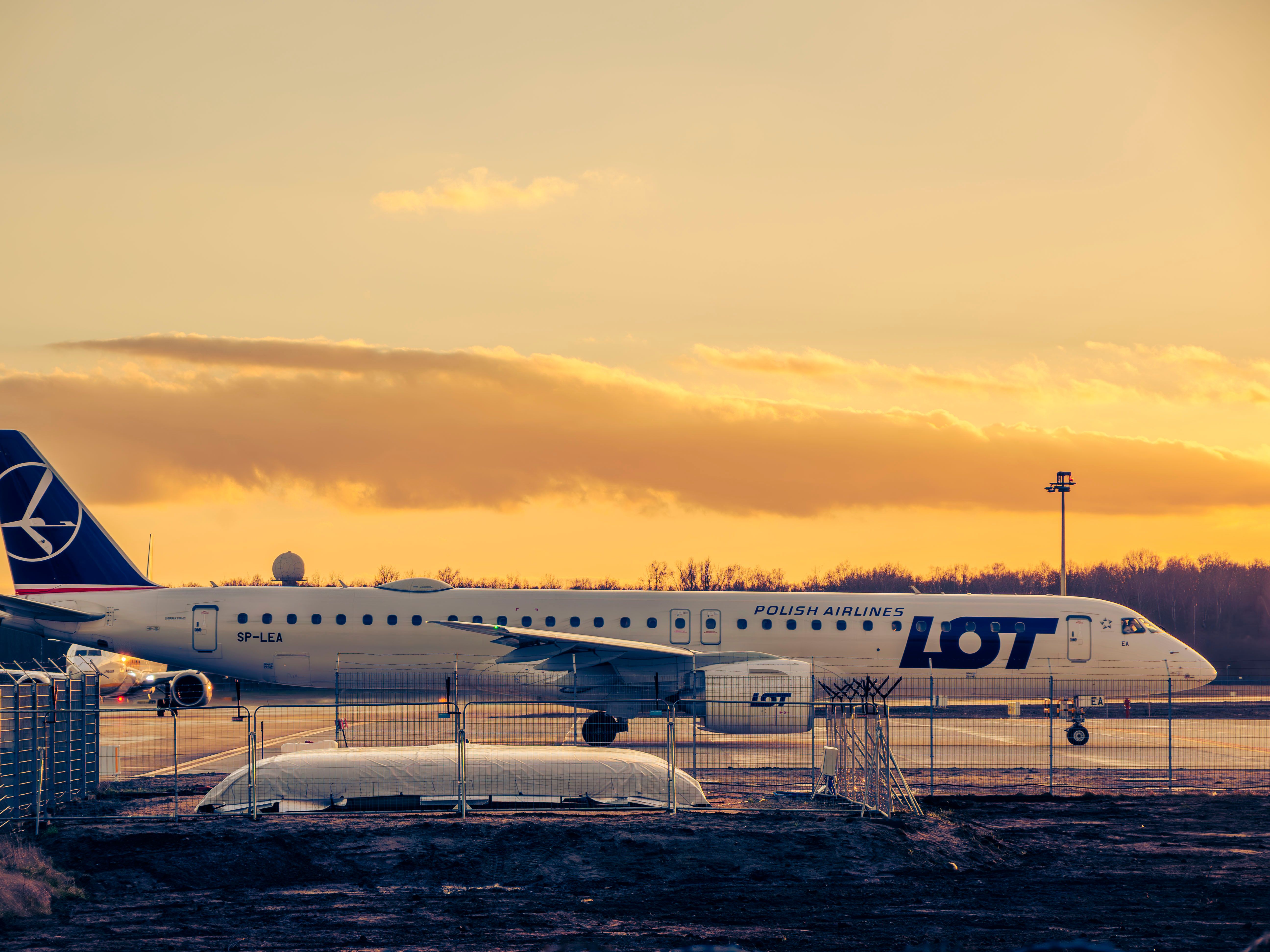A LOT Polish Airlines plane on the tarmac at Wrocław Airport during a beautiful sunset. — lounges at Wroclaw Airport