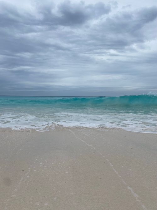Free Tranquil beach scene with gentle waves and a cloudy sky, capturing natural beauty Stock Photo