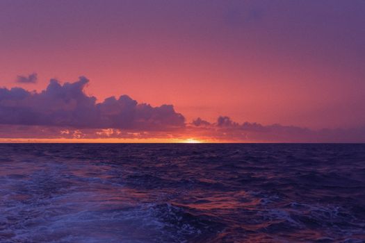 Beautiful ocean sunset with vibrant purple and orange hues painting the sky and sea.