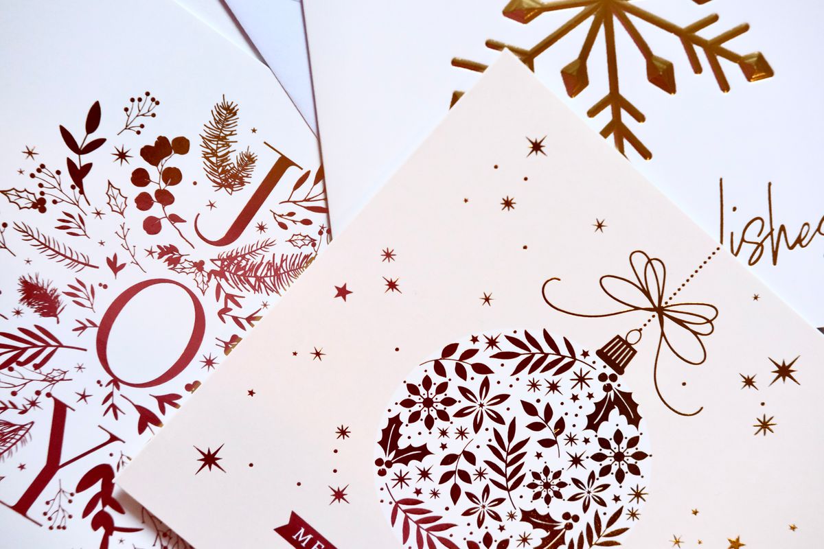 Festive greeting cards standing among Christmas ornaments