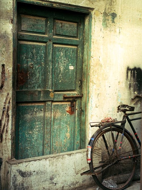 Free Old green door with a vintage bicycle in an urban setting. Stock Photo