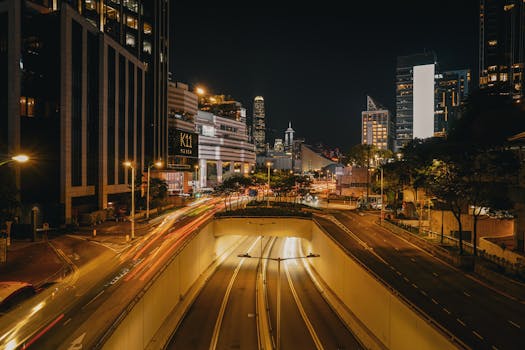 A bustling night scene in Hong Kong with illuminated streets and skyscrapers.