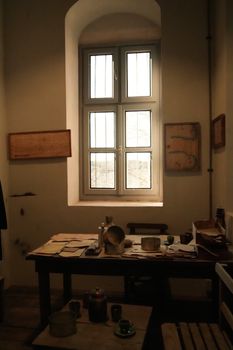 Vintage writing desk with a window view in a cozy rustic interior.