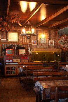 Warm rustic café interior featuring wooden furniture, vintage decor, and a unique fish tank.
