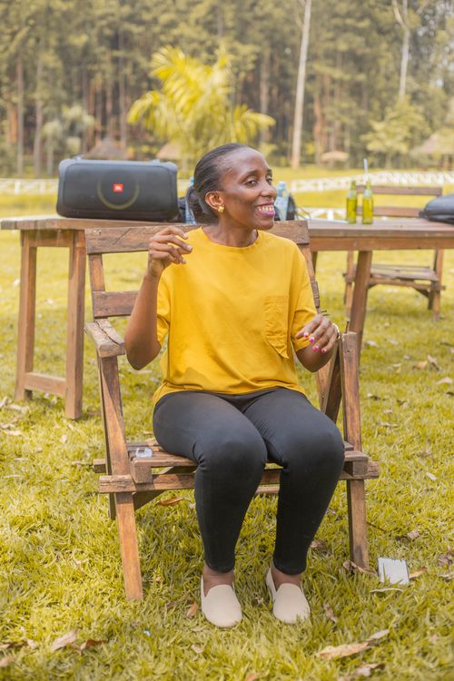 Free Woman in yellow enjoying a sunny day outdoors, sitting at a picnic table with refreshments. Stock Photo
