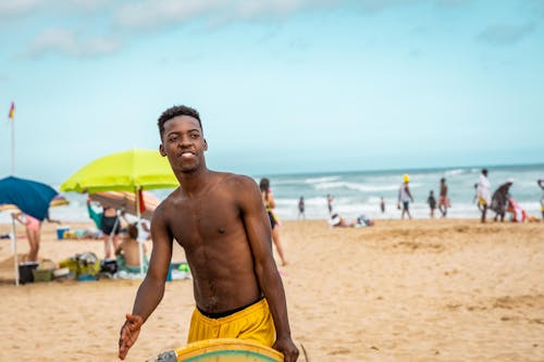 Man in Yellow Shorts Standing on Beach