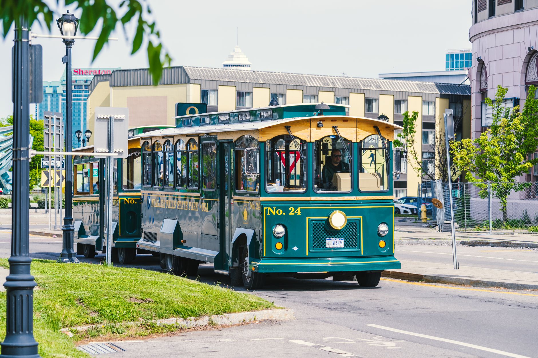 Green trolley bus at Niagara Falls State Park in summer, ideal for sightseeing and tourism.