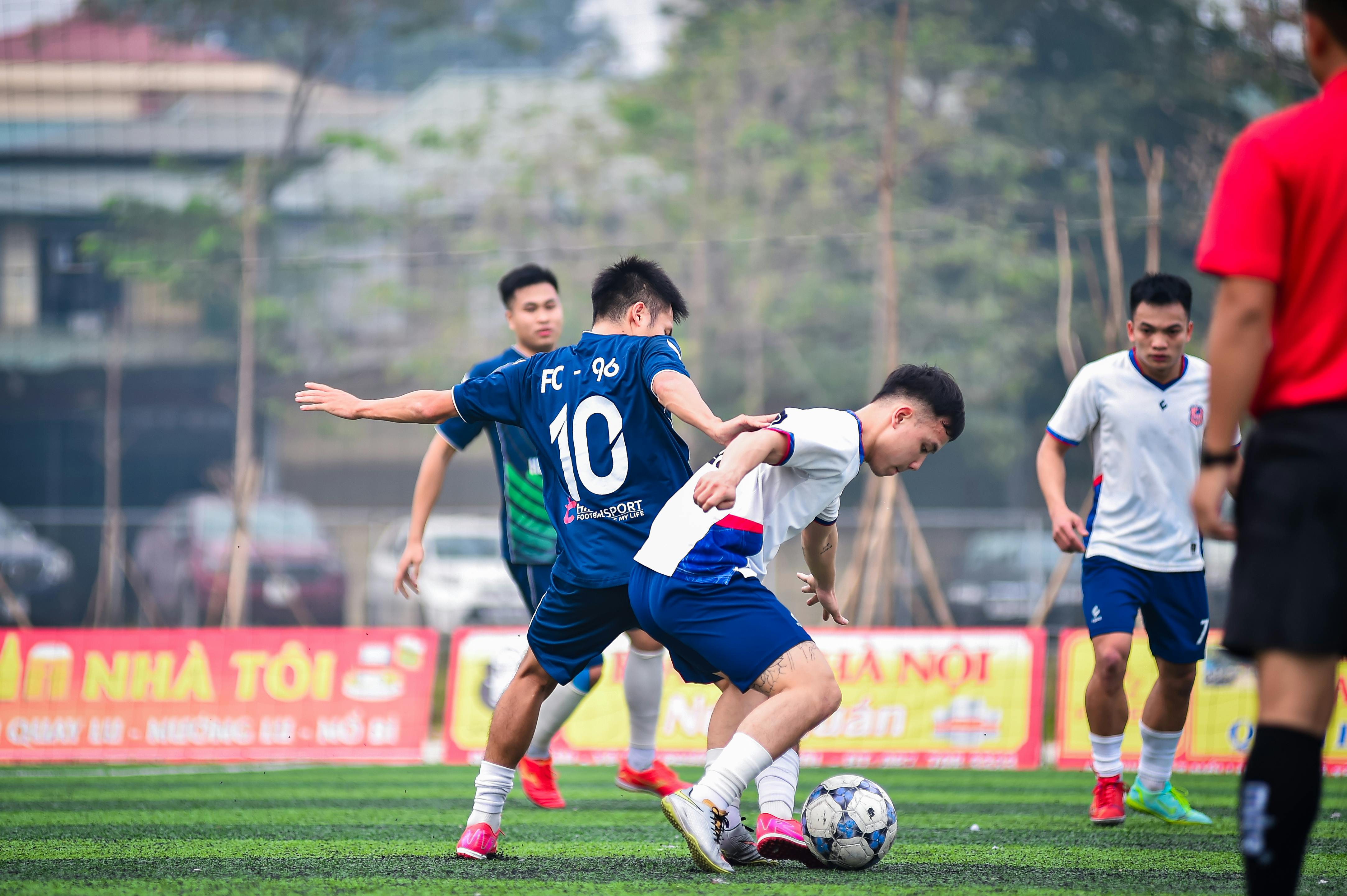 Local soccer players engaged in a dynamic match on an artificial turf field in Hà Nội, Việt Nam.