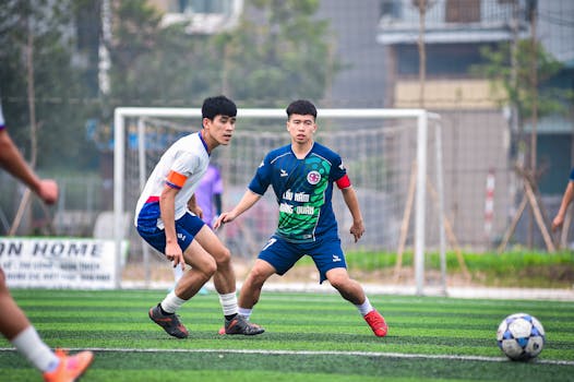 Action shot of soccer players competing on an artificial turf field in Hà Nội, Vietnam.