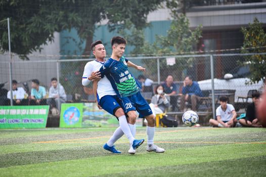 Soccer players battling on the field during a lively match in Hanoi, Vietnam.