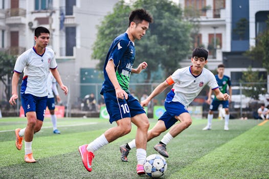 Dynamic youth soccer match at an outdoor field in Hanoi, capturing intense action and teamwork.