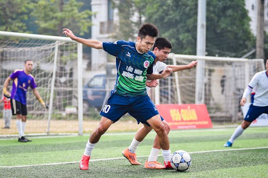 Soccer players in action on an outdoor field in Hà Nội, showcasing teamwork and competition.