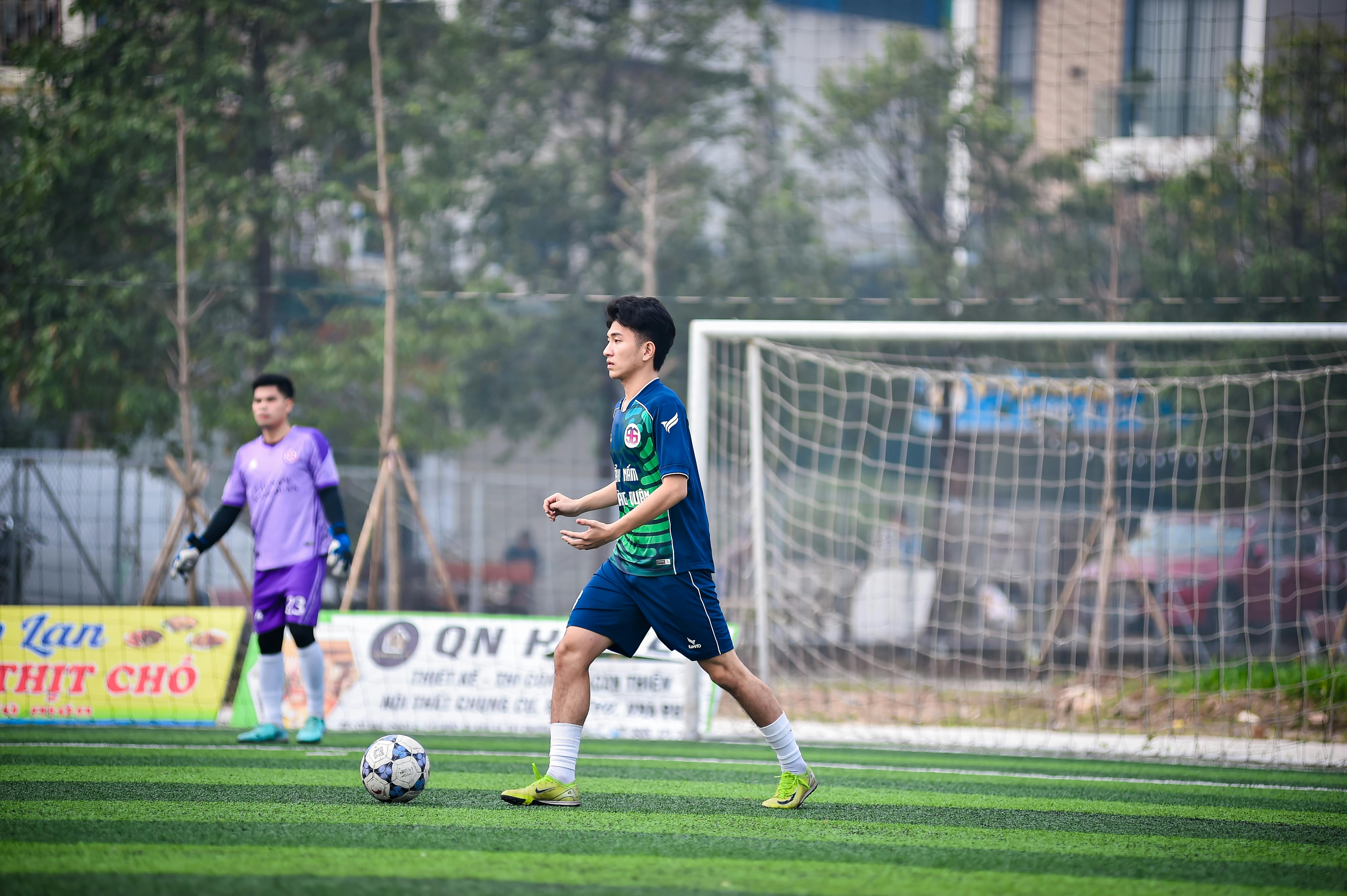 Two soccer players in action on a grassy field in Hanoi, Vietnam, showcasing teamwork and sportsmanship.