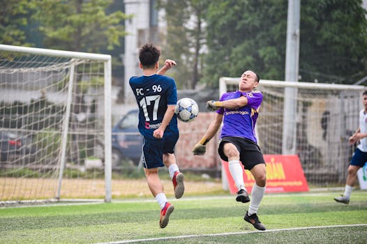 Dynamic soccer action captured on a sunny day in Hanoi, Vietnam, showcasing players' skill and competition.