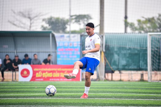 Soccer player practicing on artificial turf field in Hà Nội, capturing action and sportsmanship.