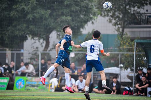 Dynamic photo capturing intense soccer action on the field in Hà Nội, fully engaged players in motion.