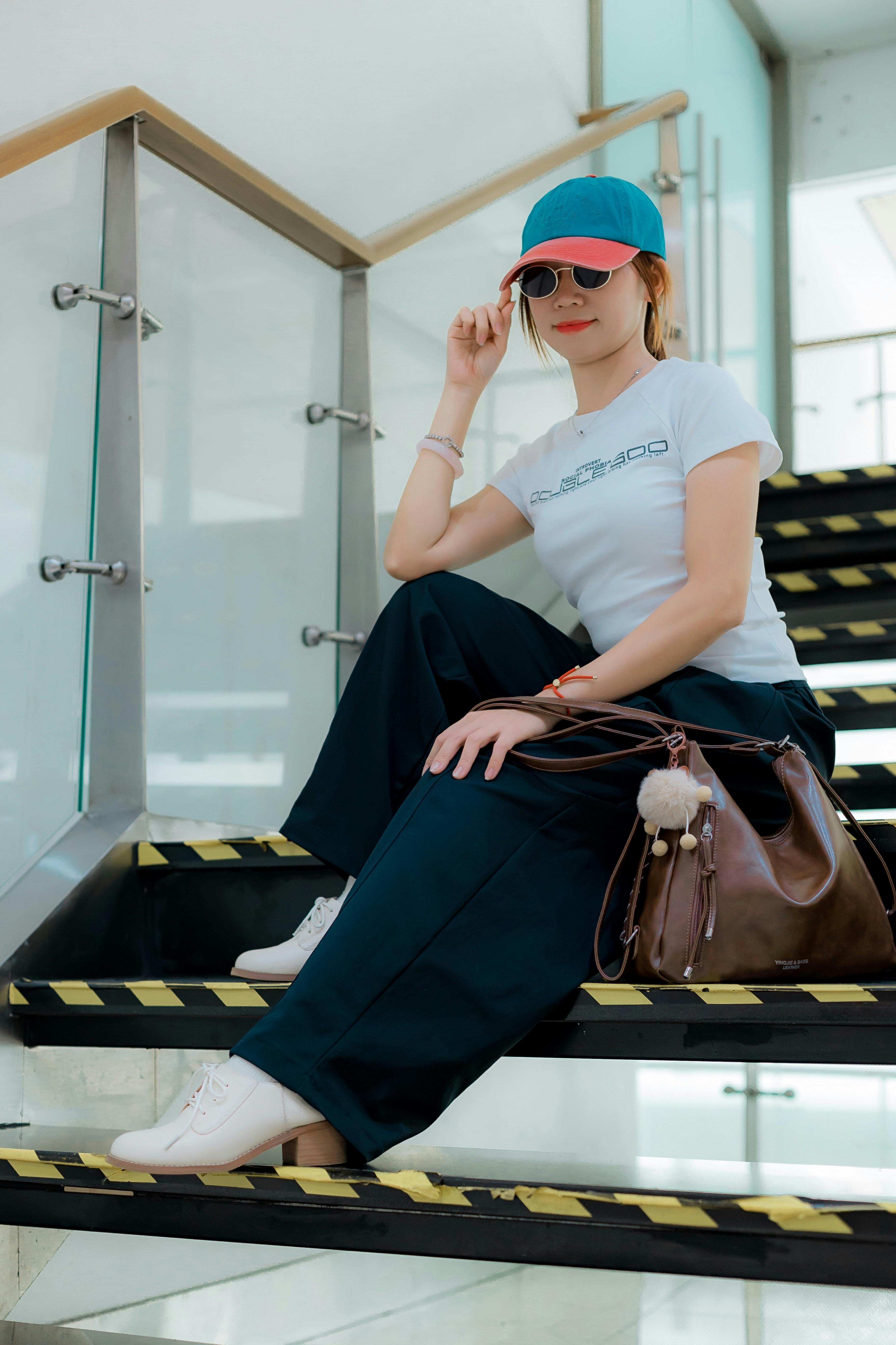 De franc Dona moderna amb roba informal a l'escala interior, que traspua un estil urbà elegant. Foto d'estoc