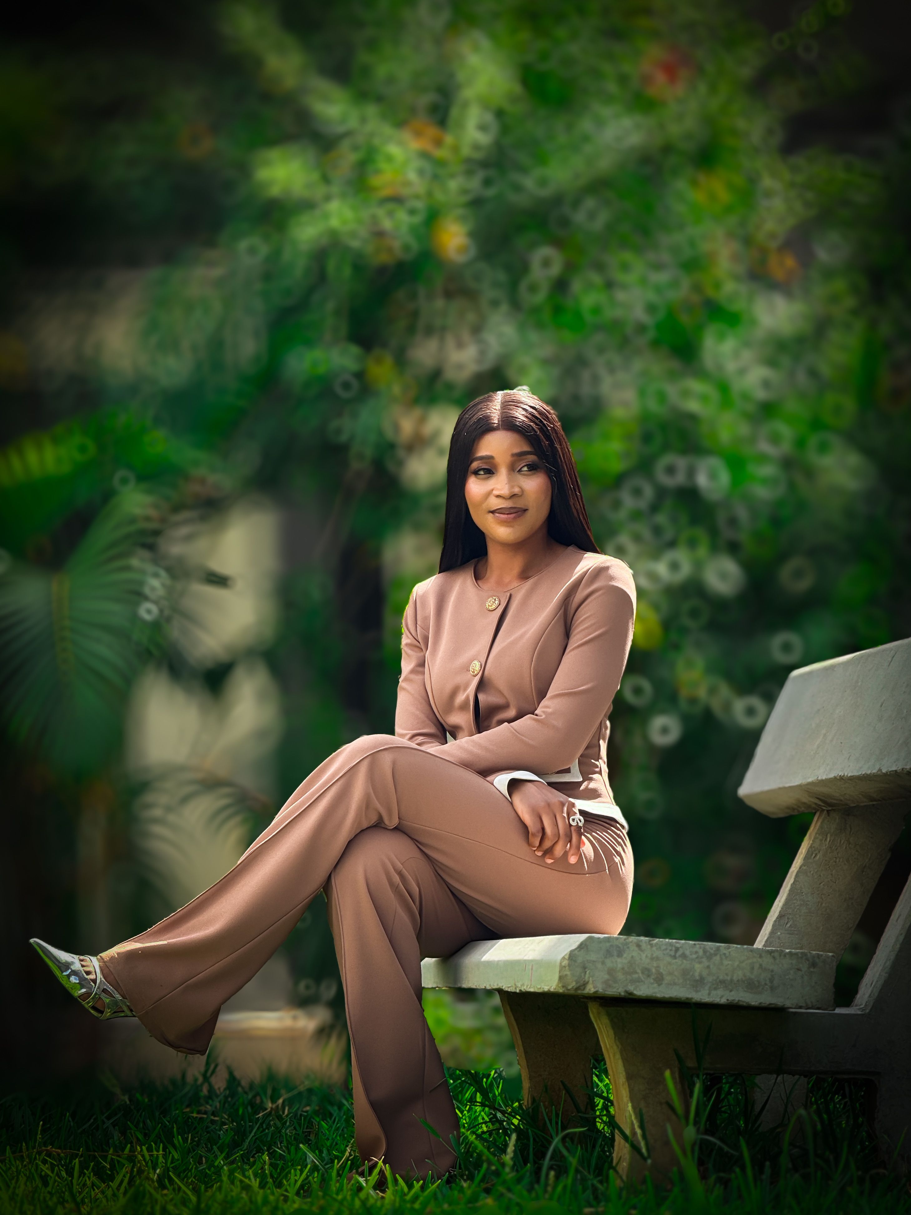 Confident Woman in Brown Suit Sitting Outdoors · Free Stock Photo