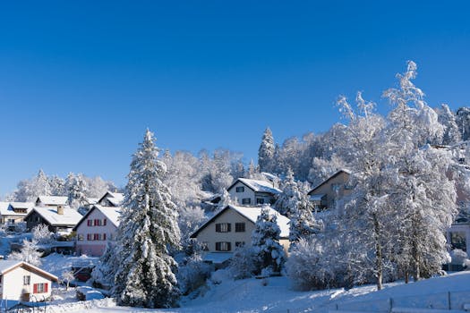 Picturesque Swiss village covered in snow with clear blue skies, showcasing winter beauty.