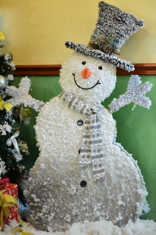 Free Artificial snowman with scarf and top hat, spreading holiday cheer indoors. Stock Photo