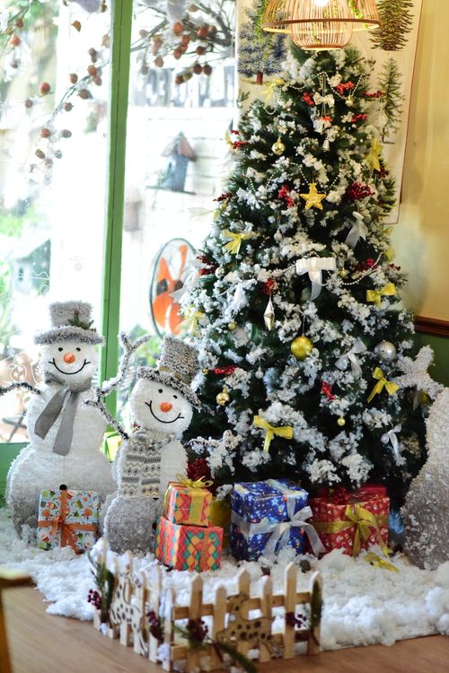 Free Beautifully decorated Christmas tree indoors with snowmen and gifts, perfect holiday ambiance. Stock Photo