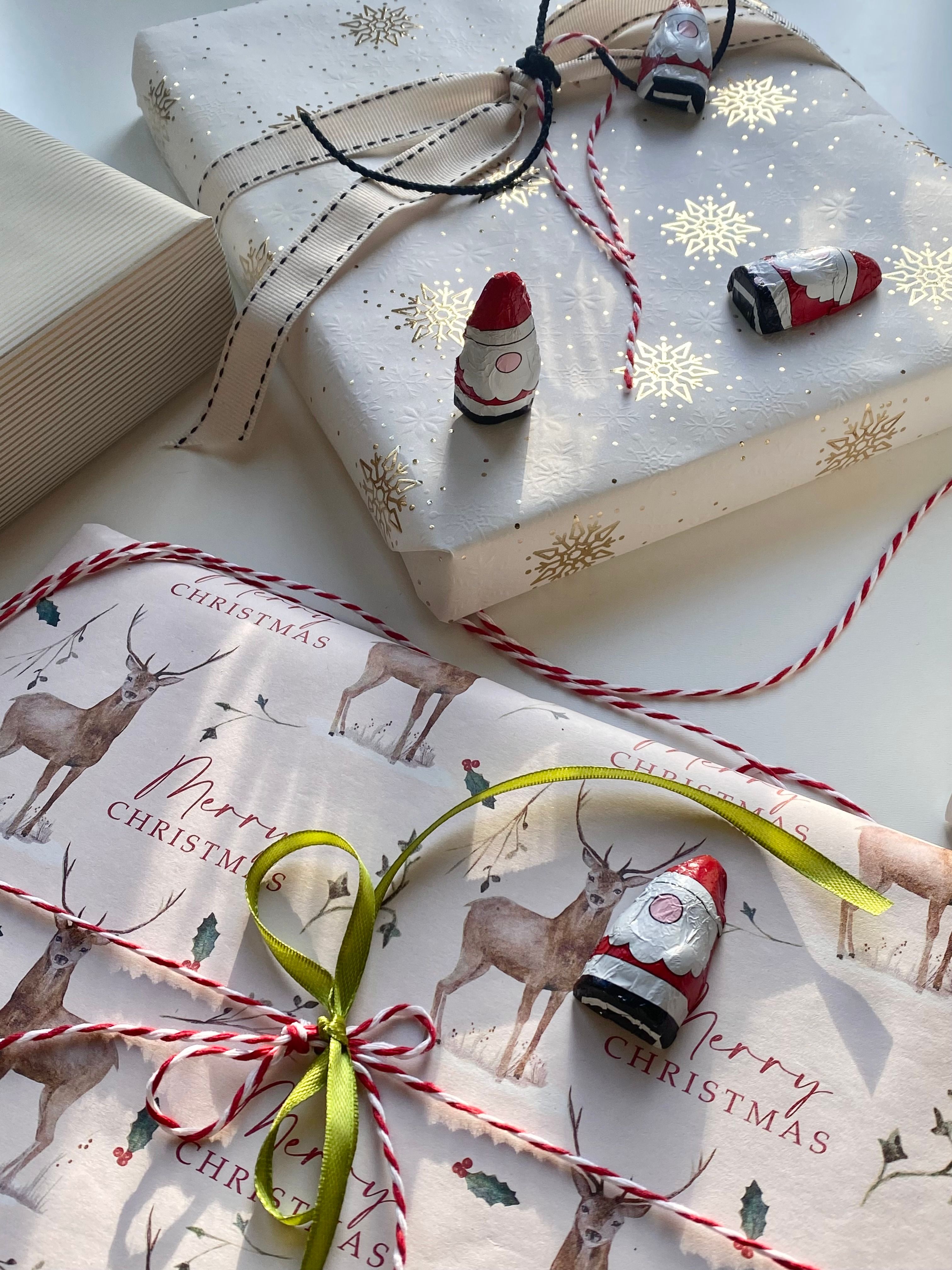 Beautifully wrapped Christmas gifts with Santa figurines and festive decorations create a seasonal holiday ambiance.
