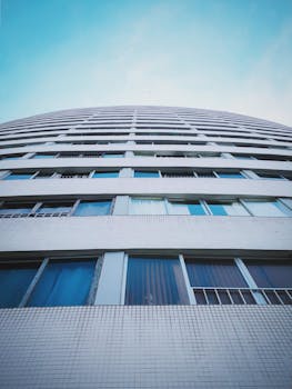 低角度镜头下，现代摩天大楼立面与晴朗蓝天交相辉映