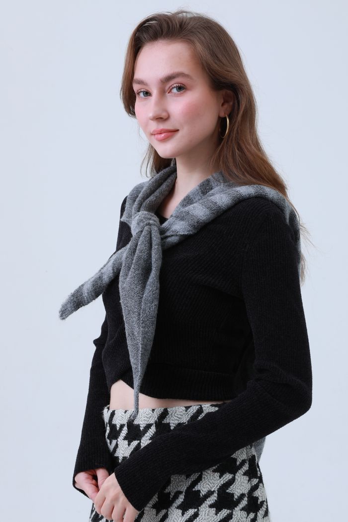 A black knit sweater worn with a grey scarf — photo by facai chen on Pexels