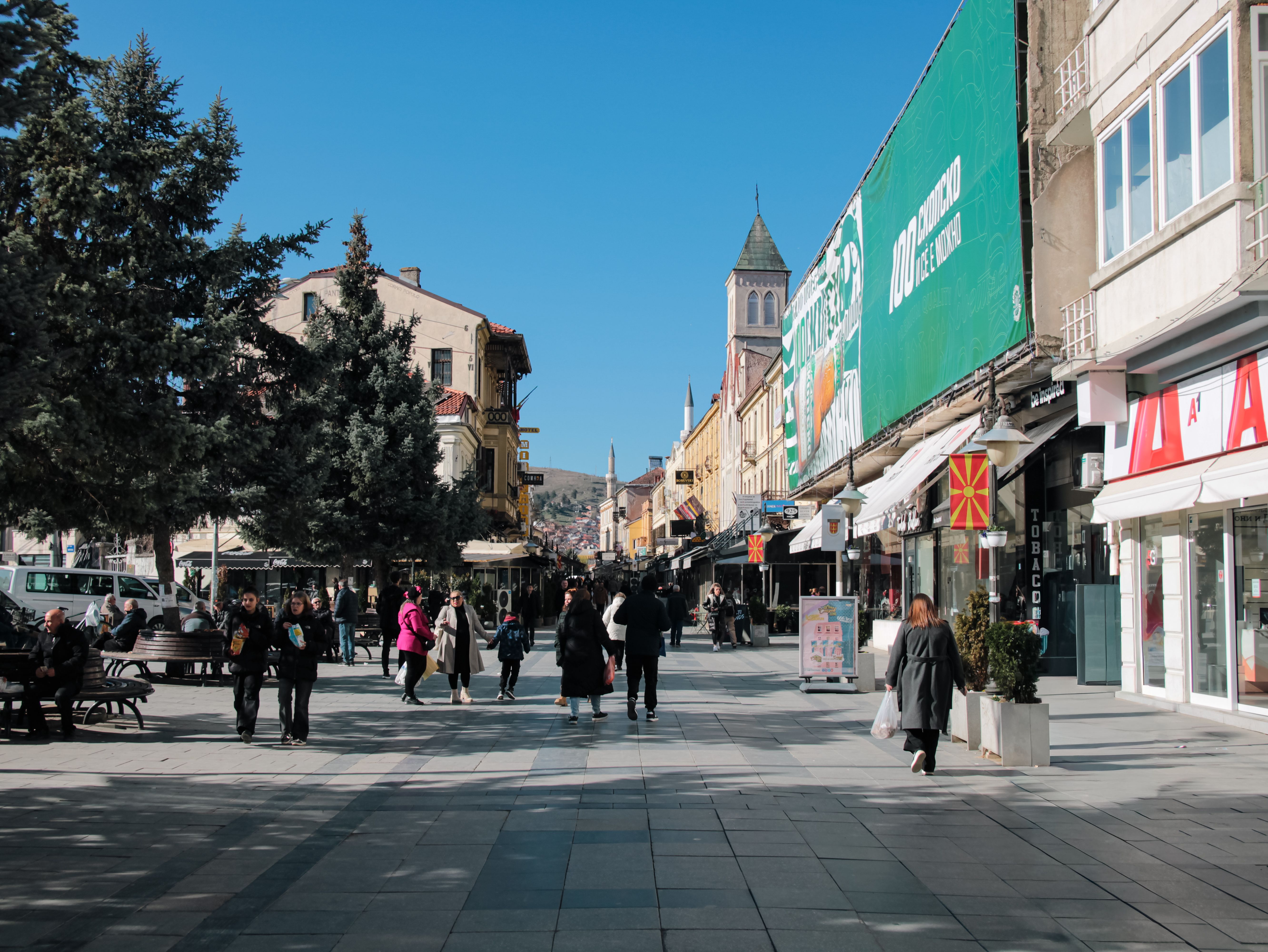 A bustling street in Bitola, North Macedonia, capturing daily life with people walking and historical architecture.