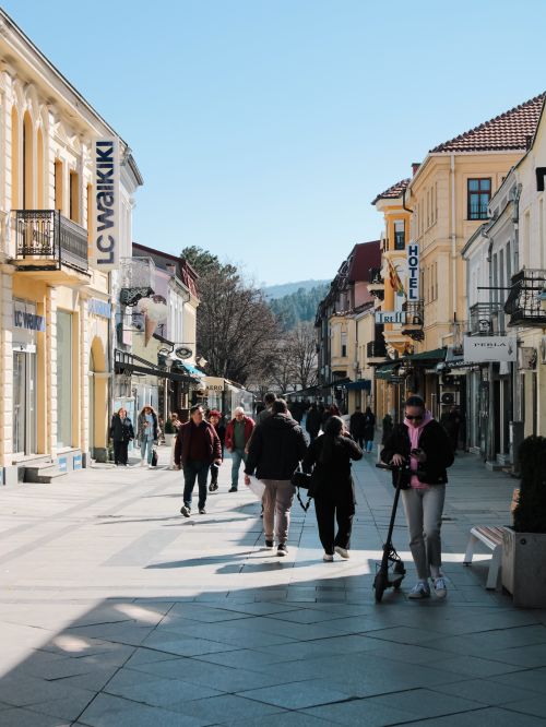 Free A bustling street scene with people walking and shopping in a European city, captured in daytime. Stock Photo