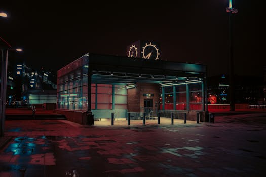 A moody, futuristic view of Malmö metro station at night with neon lights and rain reflections.