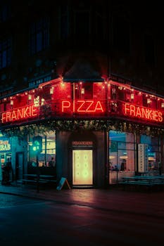 Discover the captivating neon-lit Frankies Pizza in Copenhagen's urban nightscape.