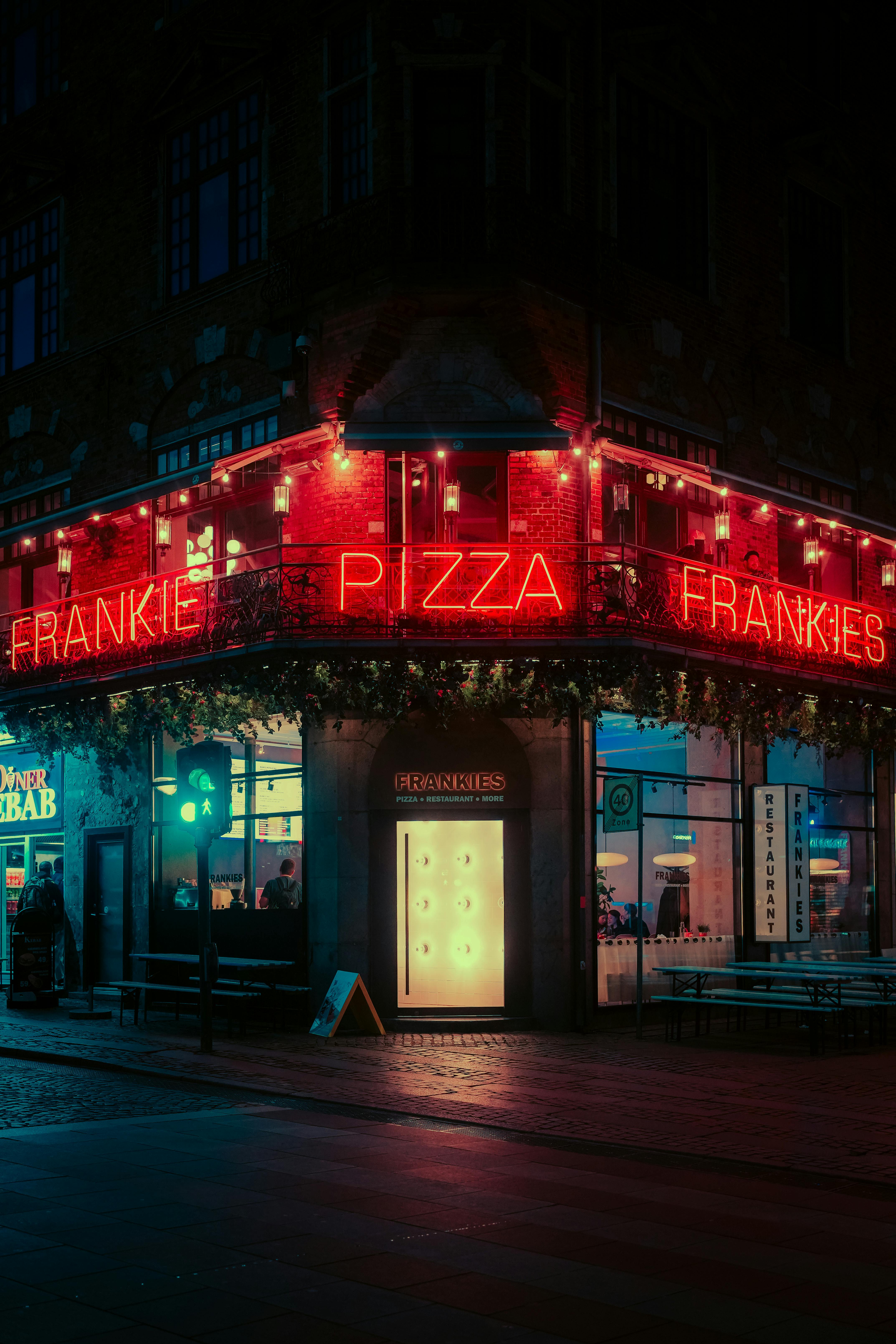 grátis Descubra a cativante Frankies Pizza, iluminada a néon, na paisagem noturna urbana de Copenhague. Foto profissional