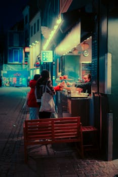 Moody urban street food vendor at night in Copenhagen, Denmark, with neon lights and vibrant atmosphere.