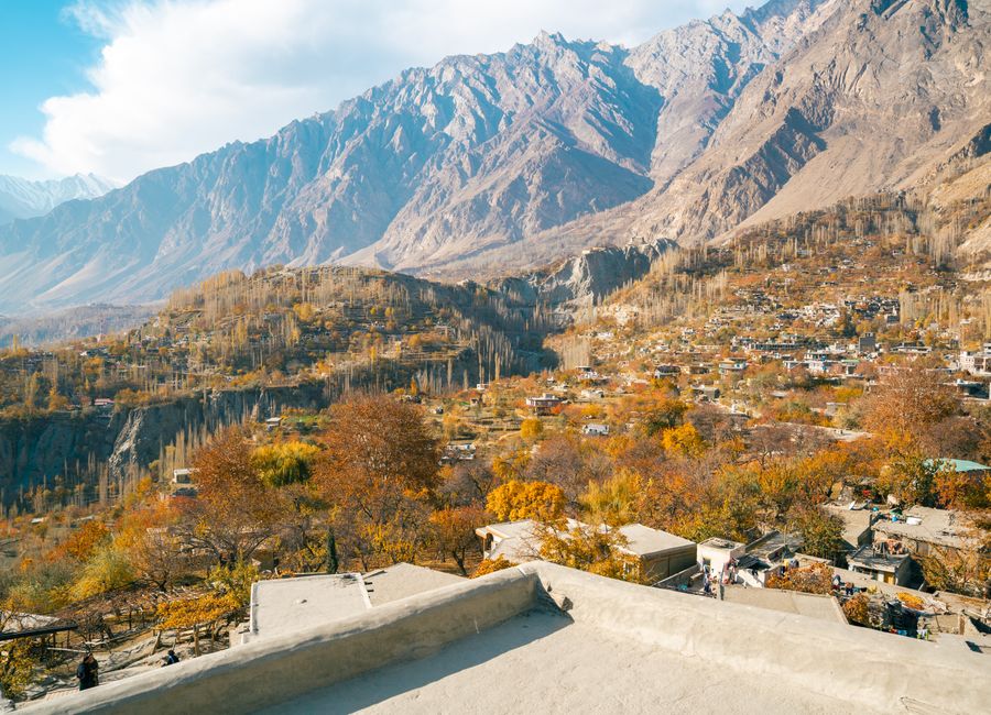 Explore the breathtaking autumn colors of Hunza Valley surrounded by majestic mountains in Pakistan.