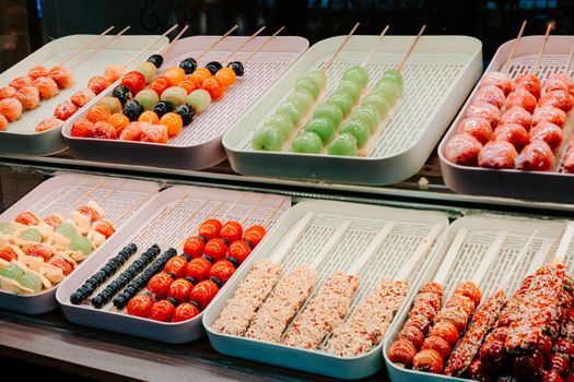 Vibrant display of traditional Chinese candied fruit skewers in Nanjing, China.