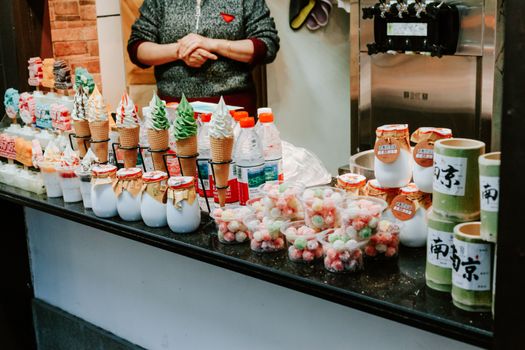 Colorful street food stall in Nanjing, showcasing traditional Chinese snacks and ice cream cones during fall.
