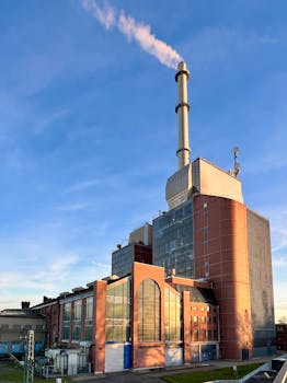 A power plant emitting smoke at sunset, showcasing industrial architecture in Karlsruhe, Germany.
