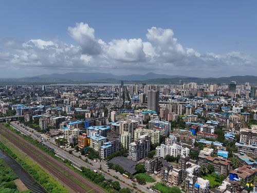 Free Aerial view of Mumbai cityscape with high rise buildings under a bright blue sky. Stock Photo