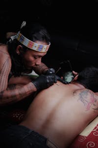 Traditional tattoo artist crafting body art