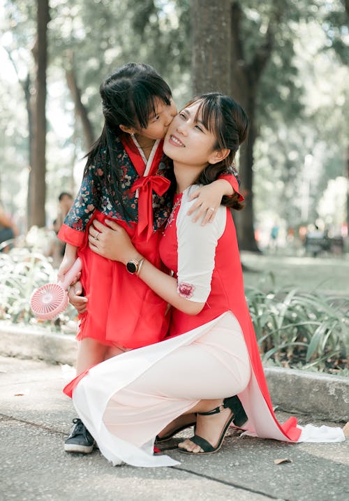 Free Girl Kissing Woman's Cheeks Stock Photo