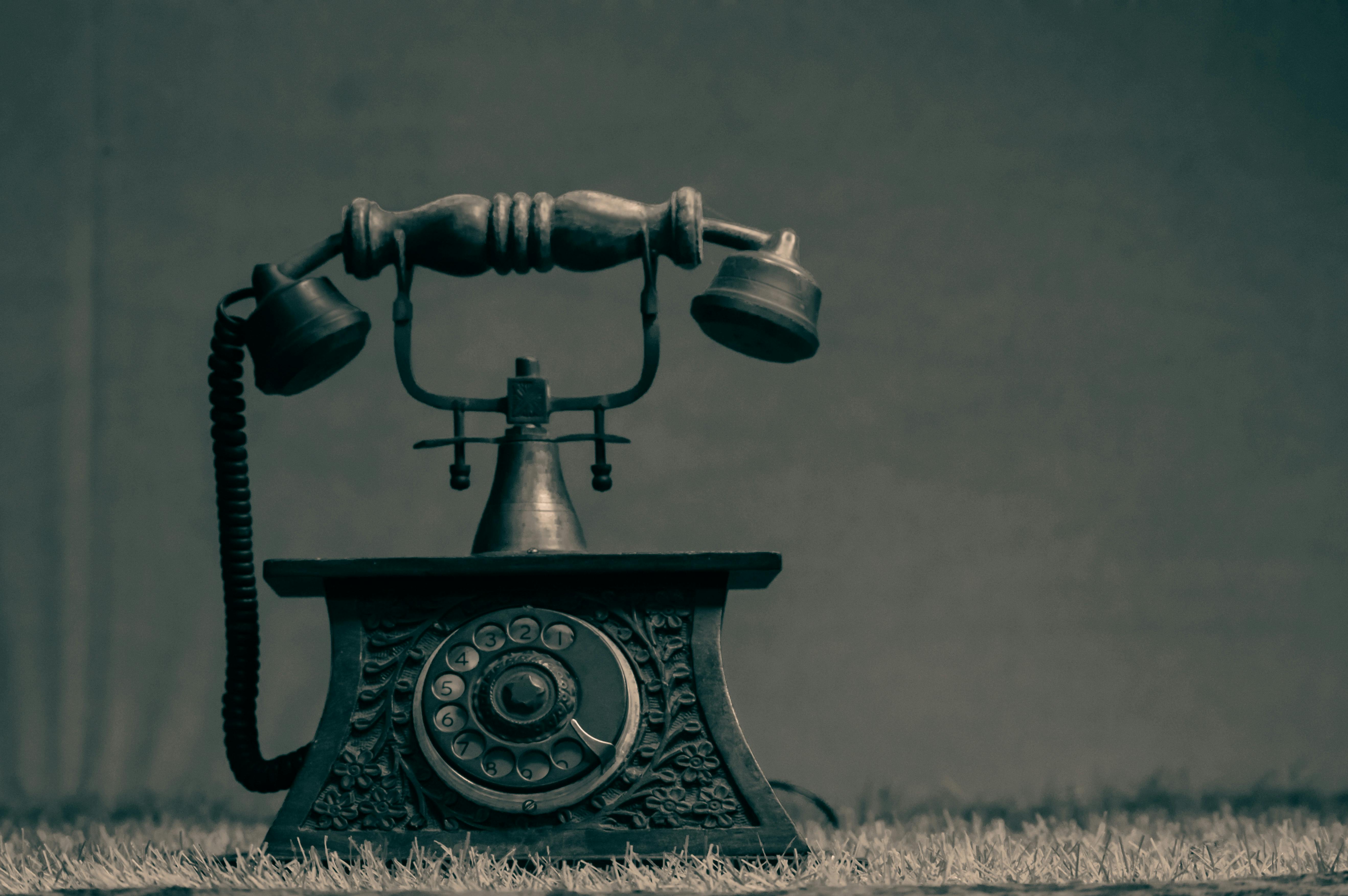 bezplatná Umělecký snímek vintage rotačního telefonu s zdobeným designem na texturovaném pozadí. Základová fotografie