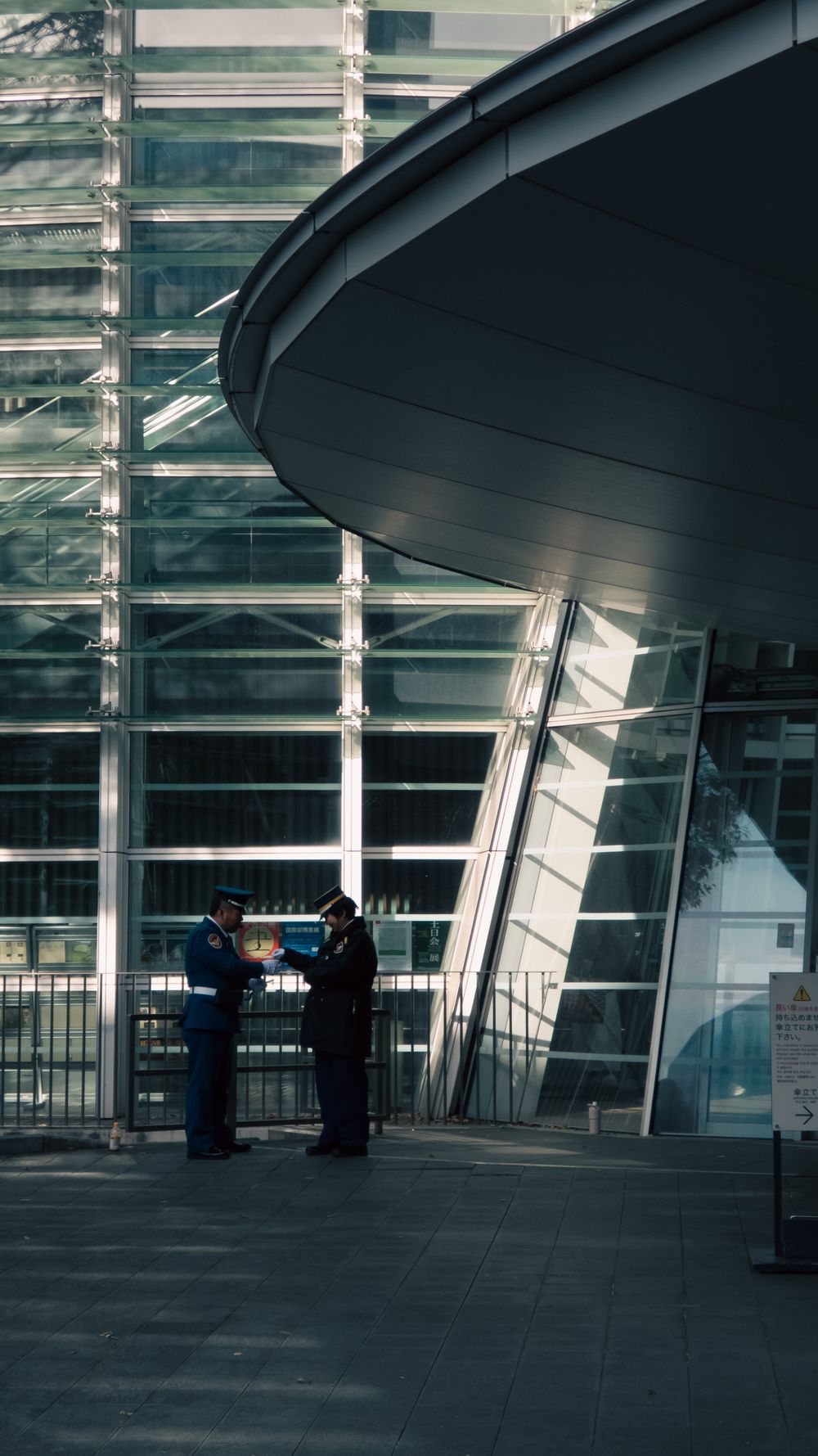 Two Trade Trade Specialists discussing a site plan outside a modern warehouse