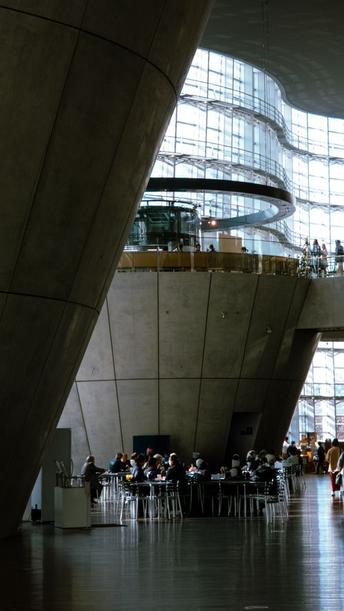 Free Spacious modern interior with people dining and distinctive architectural design. Stock Photo
