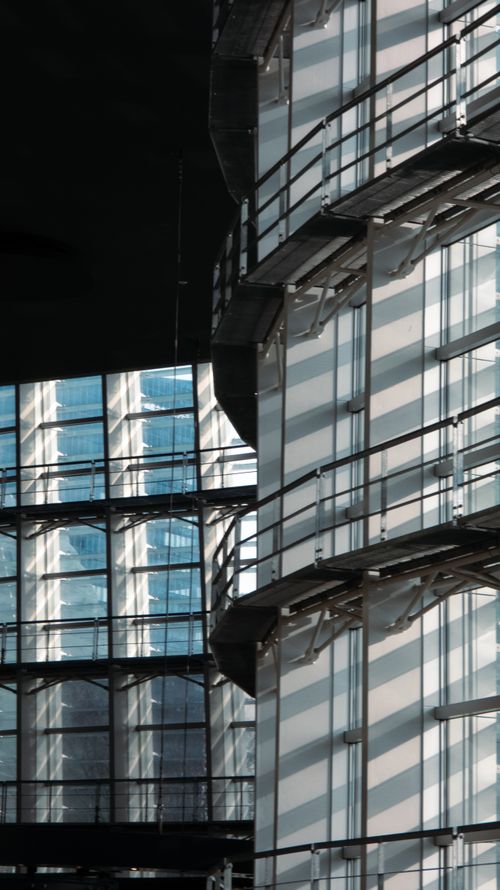 Free Dynamic shadows on a modern glass building facade, showcasing urban architectural design. Stock Photo