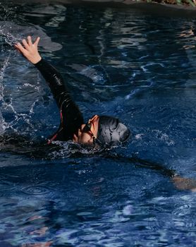 Adult swimmer in action, captured mid-stroke during daytime. Perfect for sports and fitness content.