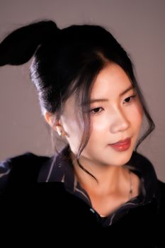 A close-up portrait of a woman with a stylish hairstyle, exuding elegance and poise.